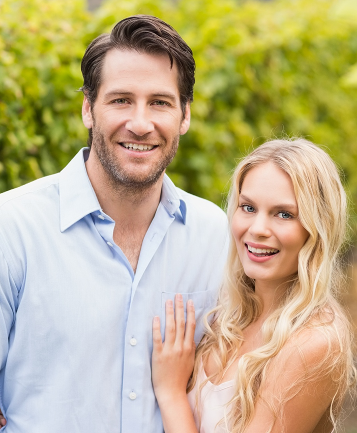 Smiling couple standing outdoors together, representing love, connection, and healthy relationships