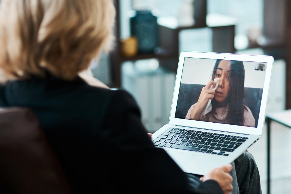 Therapist speaking with a client through an online video therapy session