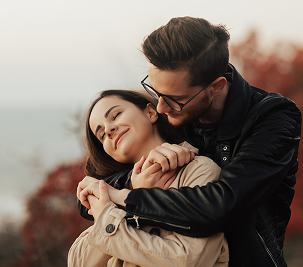 Couple embracing affectionately outdoors during autumn