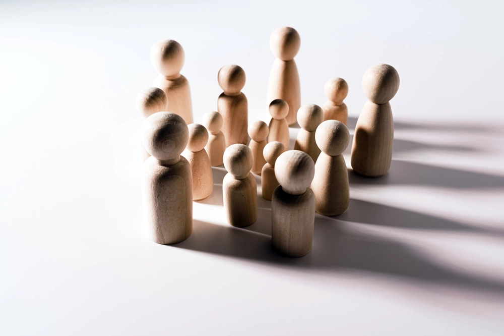 Group of wooden figurines of varying sizes arranged together on a white surface