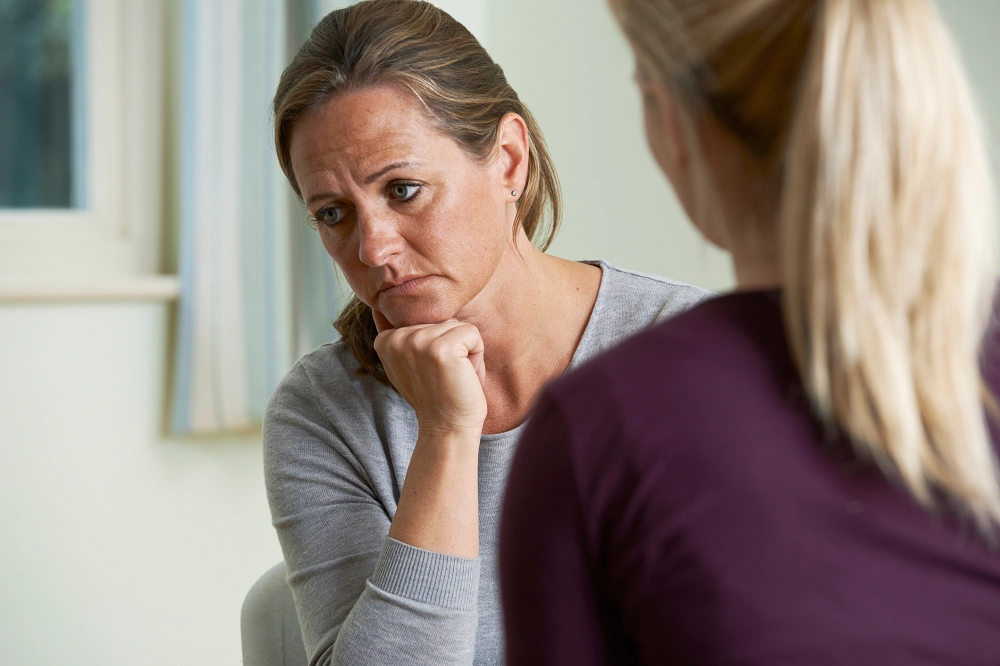 Concerned middle-aged woman listening during a conversation with another person